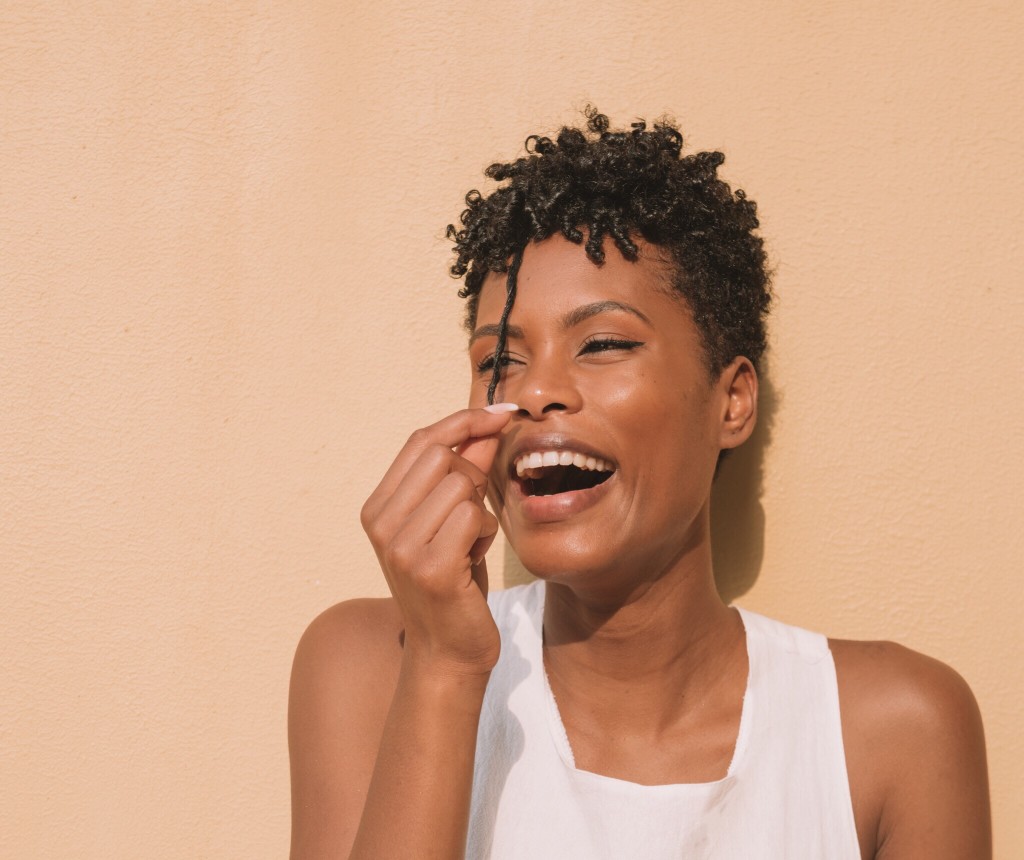 beautiful woman pulling curl with fingers and smiling