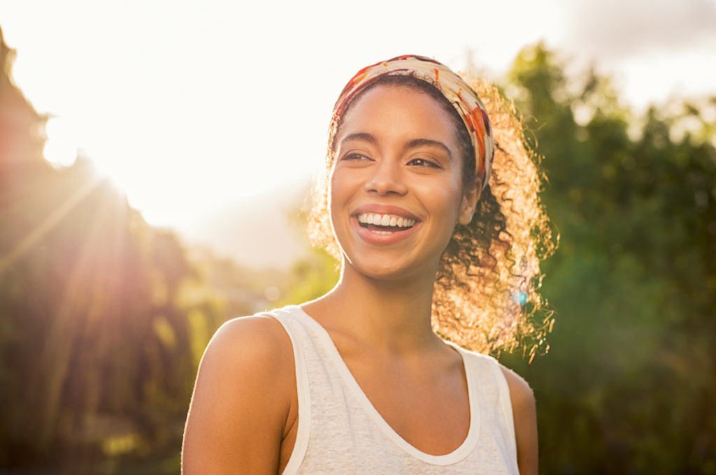 woman with colorful headband smiling outside