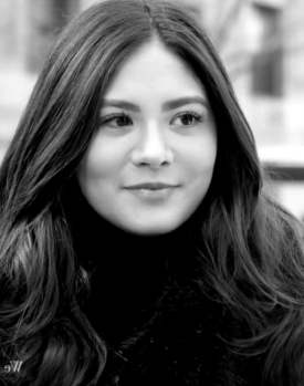 dark haired woman smiling outside black and white