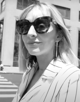 smiling woman wearing sunglasses by the street