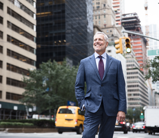 Dr. Pearlman smiling in the city streets in a suit