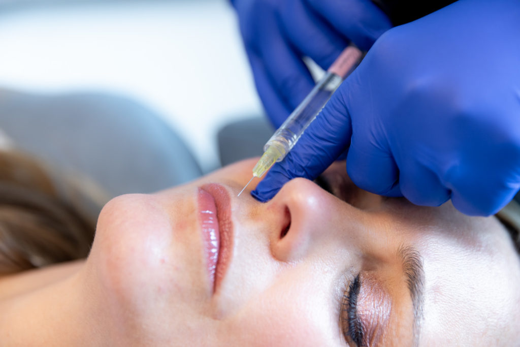 specialist in gloves injecting woman's lips