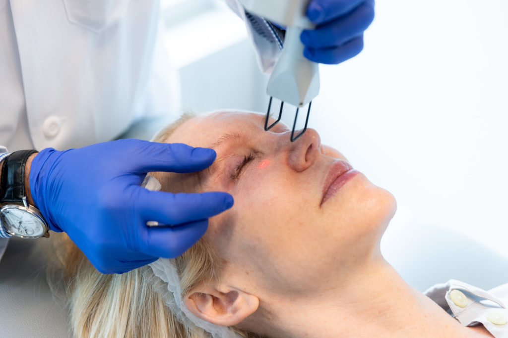 Dr. Pearlman using laser on patient's face