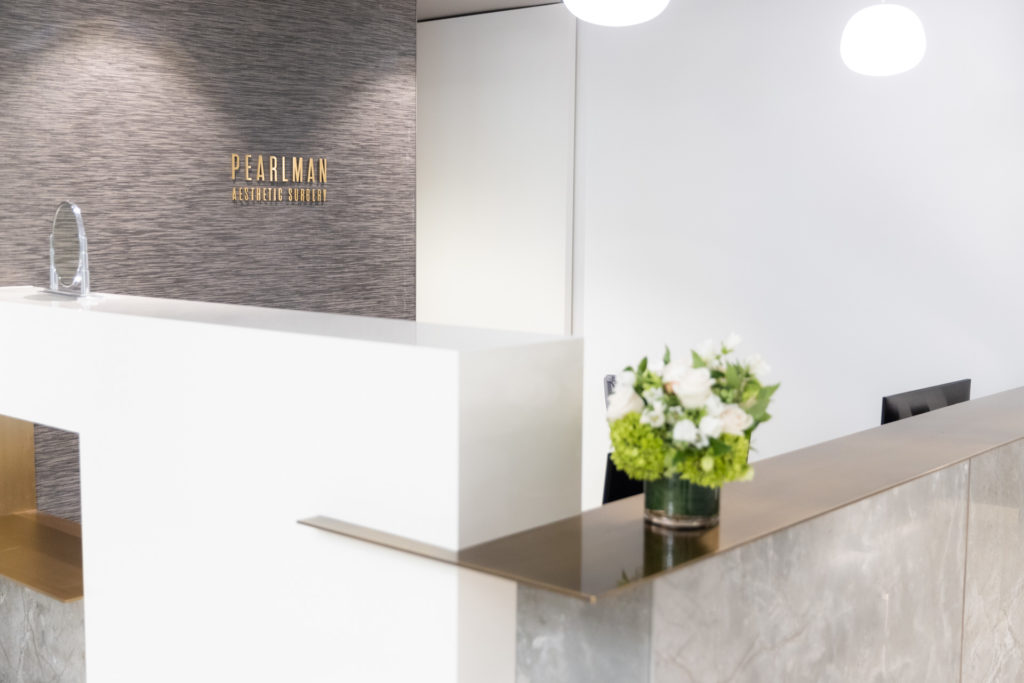 empty front desk with flowers and Pearlman sign