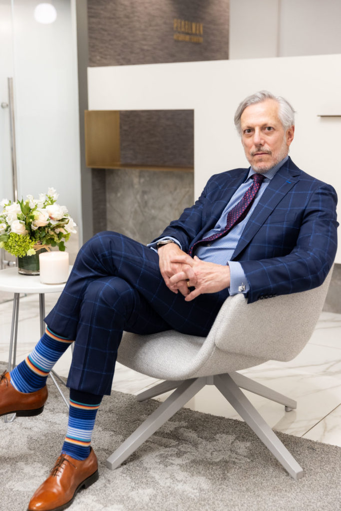 Dr. Pearlman sitting in chair by flowers