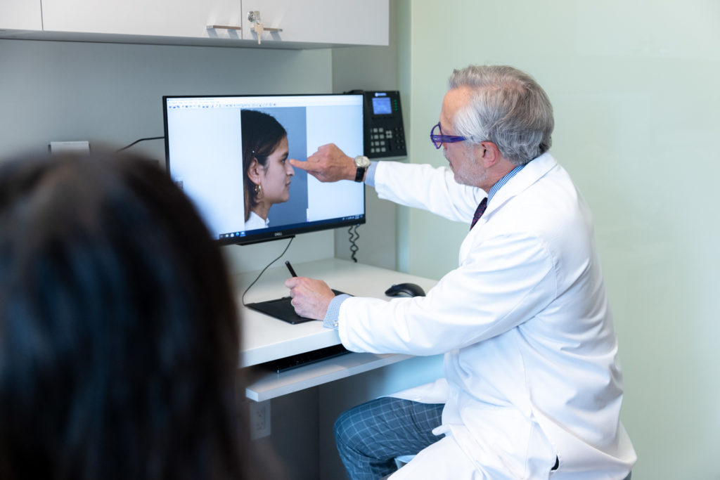 Dr. Pearlman showing patient pictures before rhinoplasty in New York office