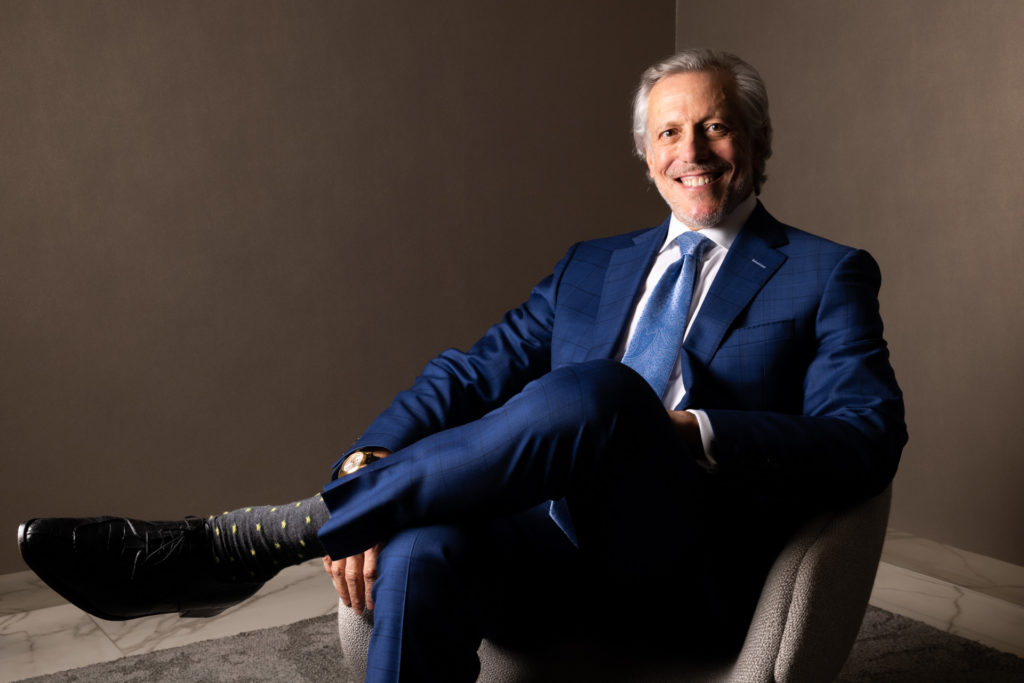 Dr. Pearlman sitting in chair smiling