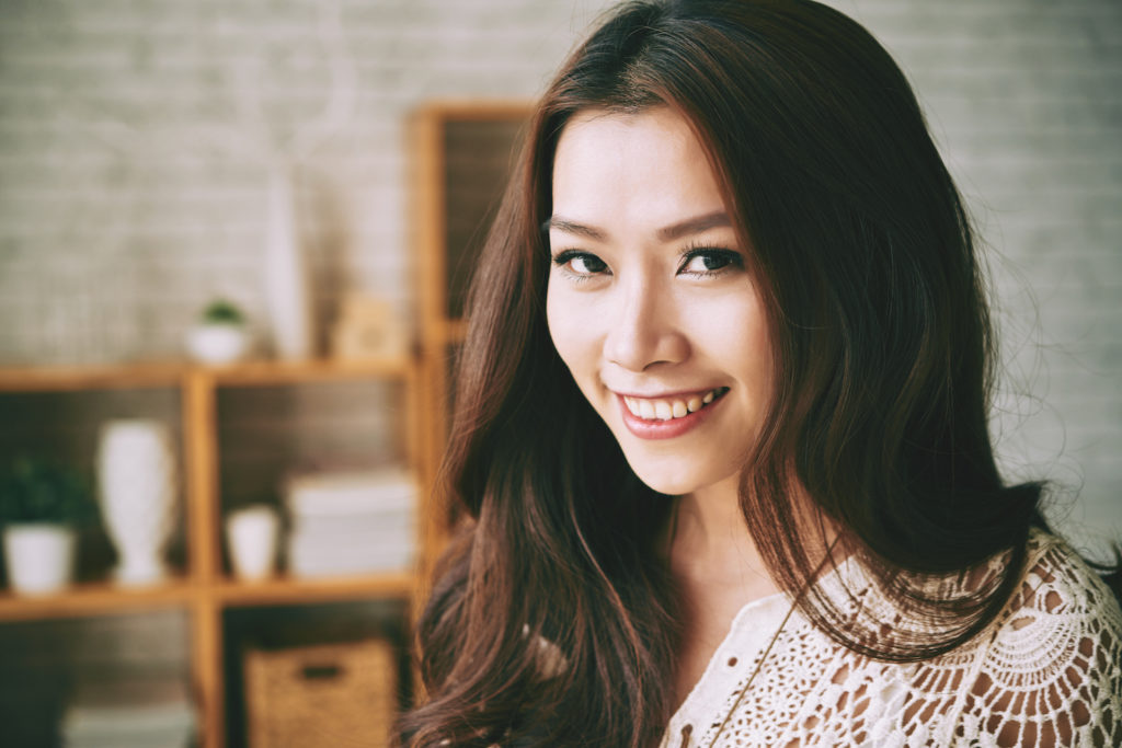 woman with curled hair smiling in crochet top