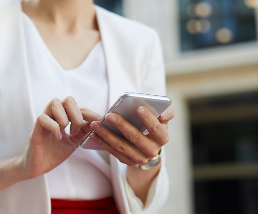 woman in white blazer on silver phone