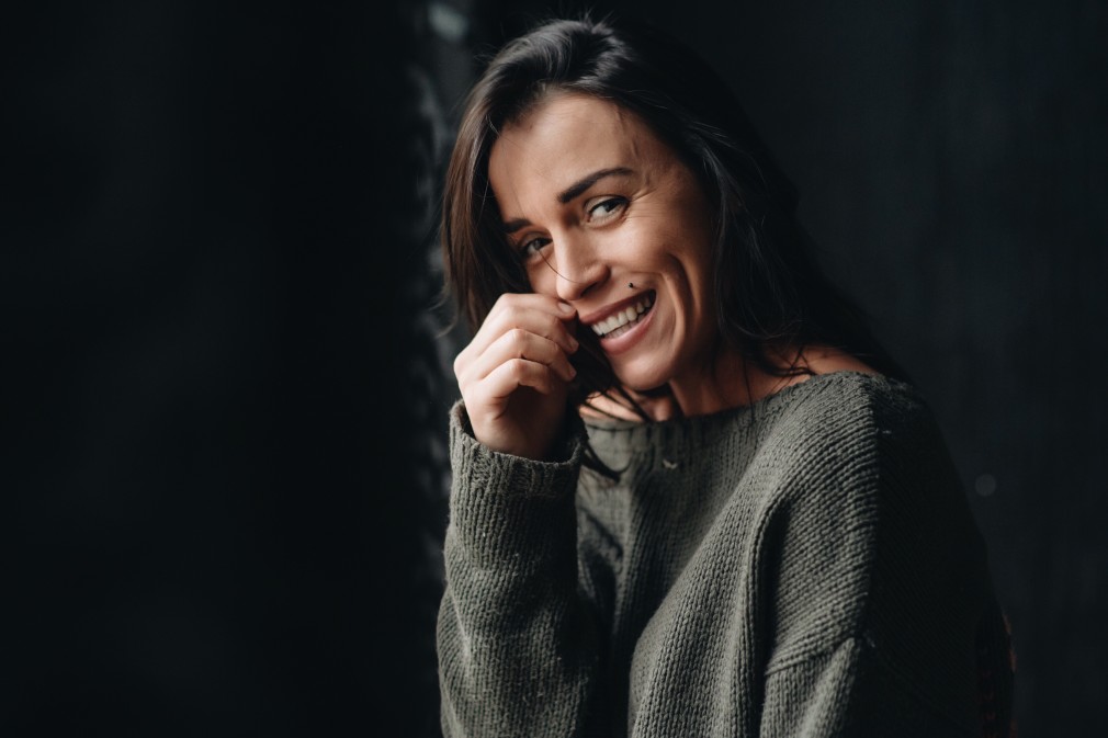 woman smiling with hand on face