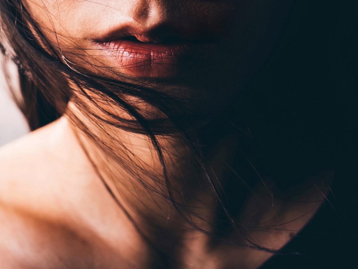 woman with plump lips and blowing long brown hair