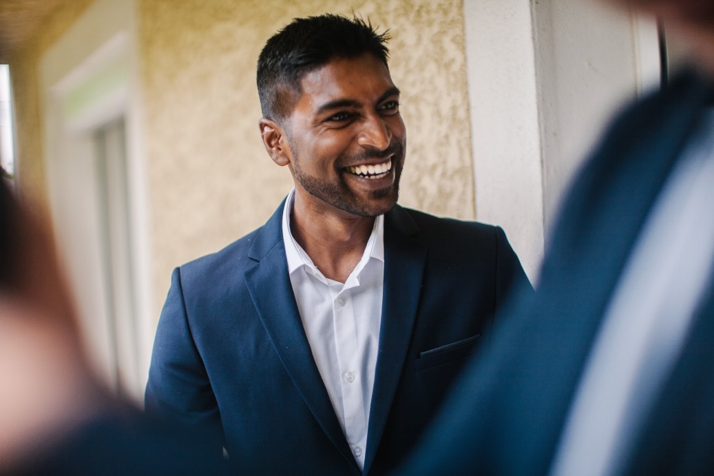 young man in a blazer laughing